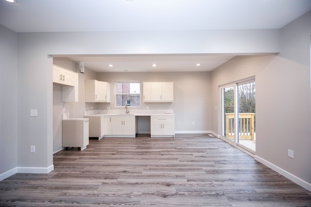 kitchen featuring sink, white cabinets, and light wood-type flooring