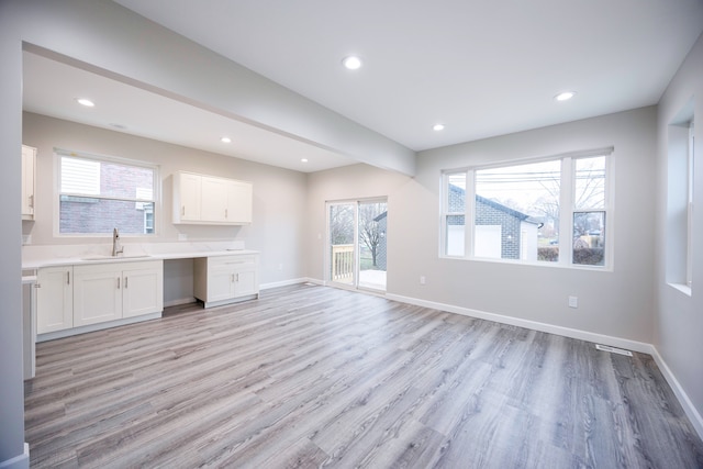 kitchen featuring sink, white cabinets, and light wood-type flooring