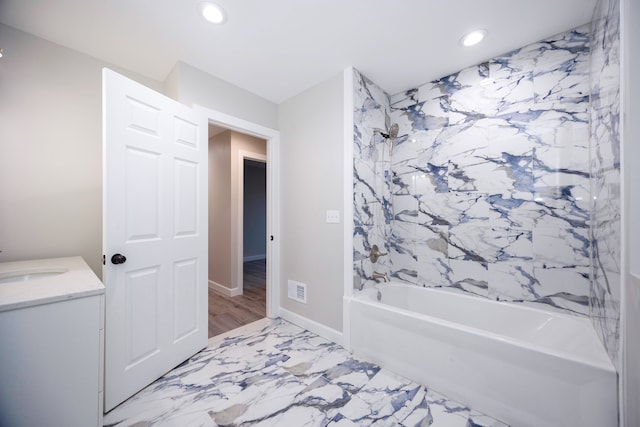 bathroom with hardwood / wood-style flooring, vanity, and bathtub / shower combination