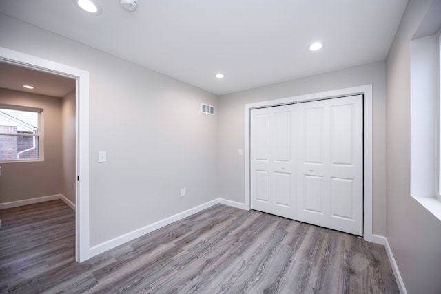 unfurnished bedroom with a closet and wood-type flooring