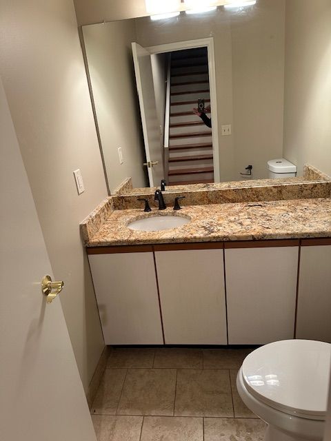 bathroom with tile patterned flooring, vanity, and toilet