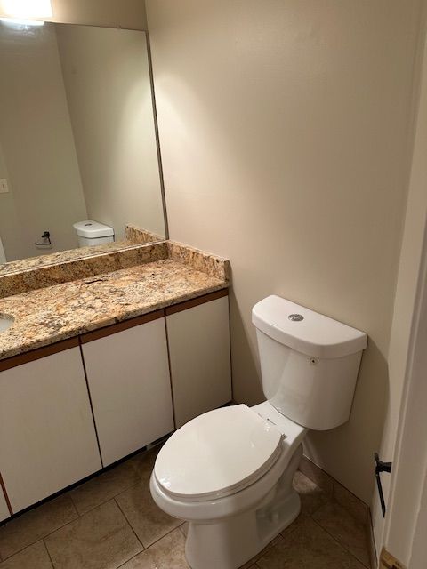 bathroom featuring tile patterned floors, vanity, and toilet