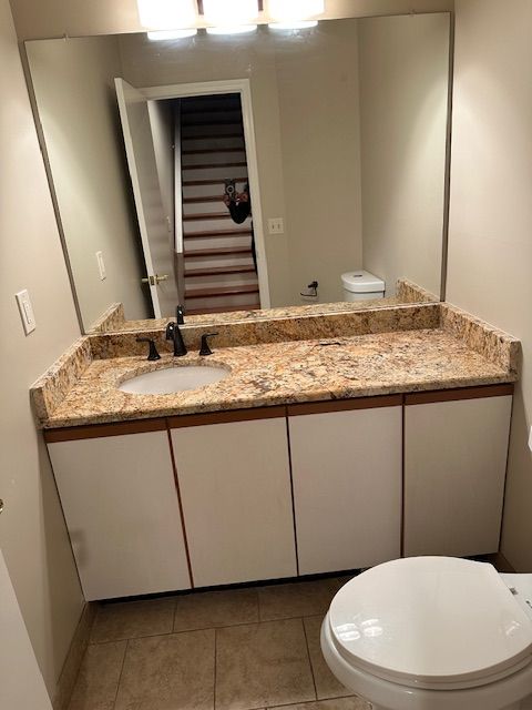 bathroom with tile patterned flooring, vanity, and toilet