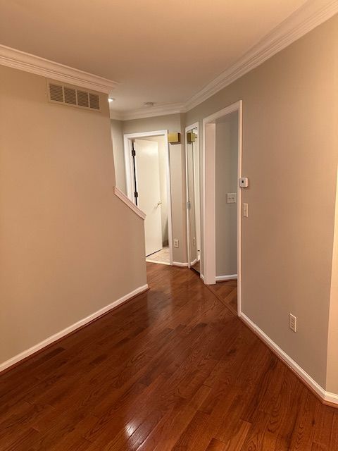 unfurnished room featuring dark hardwood / wood-style floors and ornamental molding