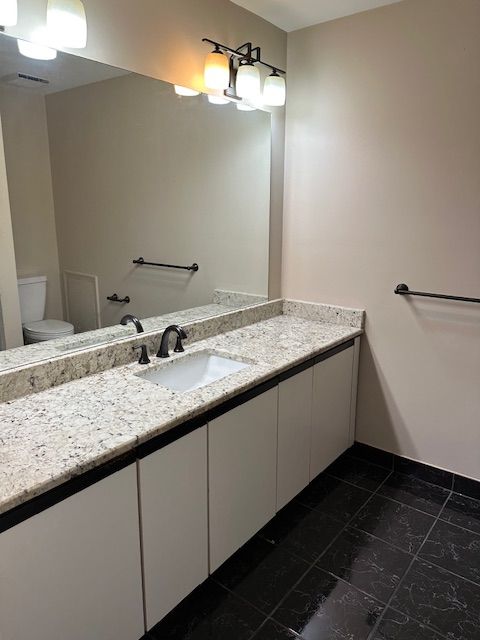 bathroom with tile patterned floors, vanity, and toilet