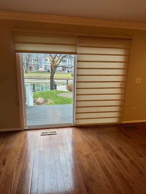 doorway with crown molding and hardwood / wood-style floors