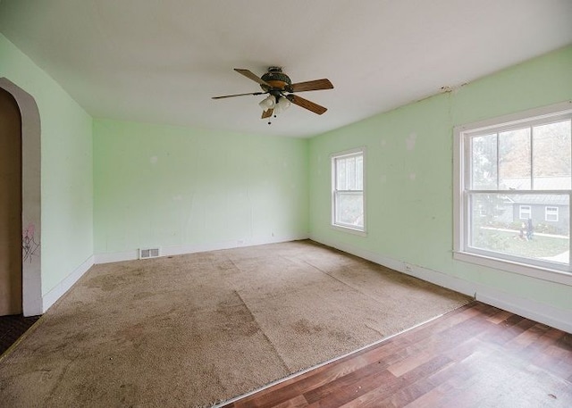 unfurnished room with a wealth of natural light, ceiling fan, and hardwood / wood-style flooring