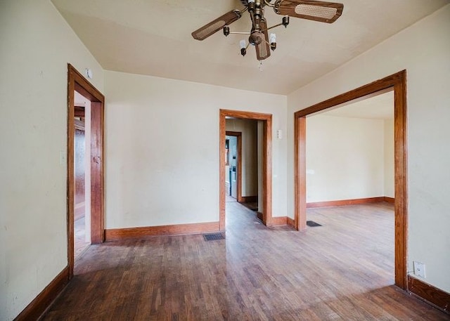 unfurnished room with ceiling fan and dark wood-type flooring