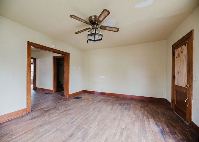 unfurnished room featuring ceiling fan and dark wood-type flooring