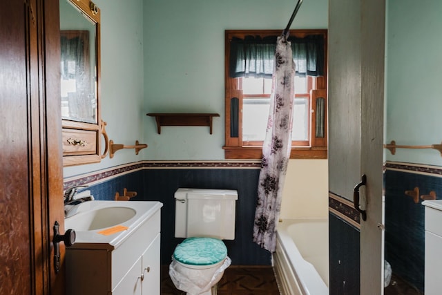 full bathroom featuring shower / tub combo with curtain, vanity, tile walls, and toilet