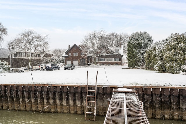 yard layered in snow featuring a water view