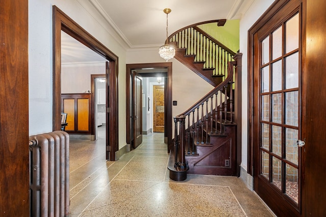 entrance foyer featuring an inviting chandelier, radiator, and crown molding