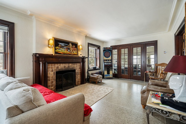 living room with a stone fireplace, french doors, a healthy amount of sunlight, and ornamental molding