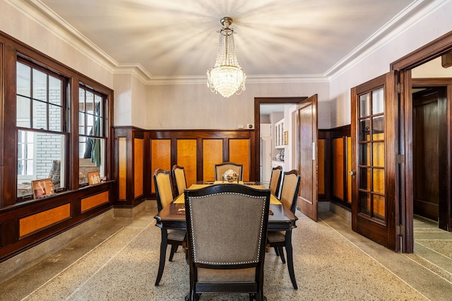 dining area with crown molding and a chandelier