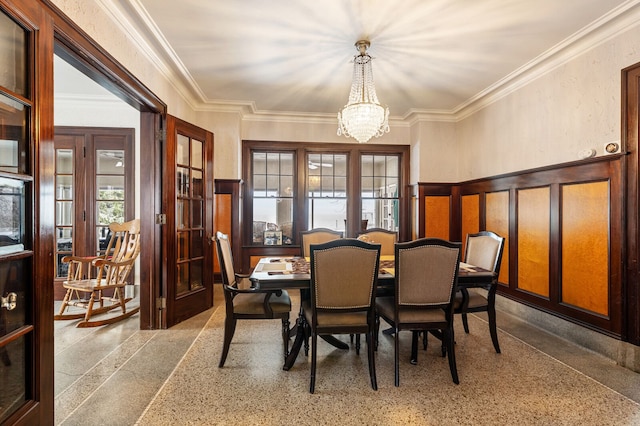 dining area featuring french doors, ornamental molding, and a notable chandelier