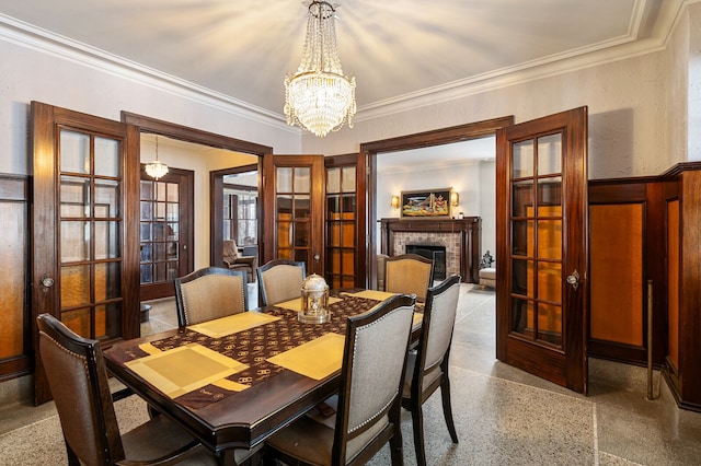 dining area featuring an inviting chandelier, crown molding, and french doors