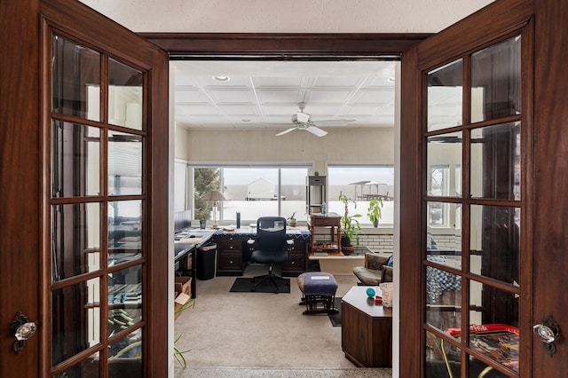 carpeted office featuring ceiling fan and coffered ceiling