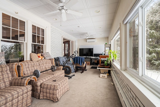 sunroom featuring a wall unit AC and ceiling fan