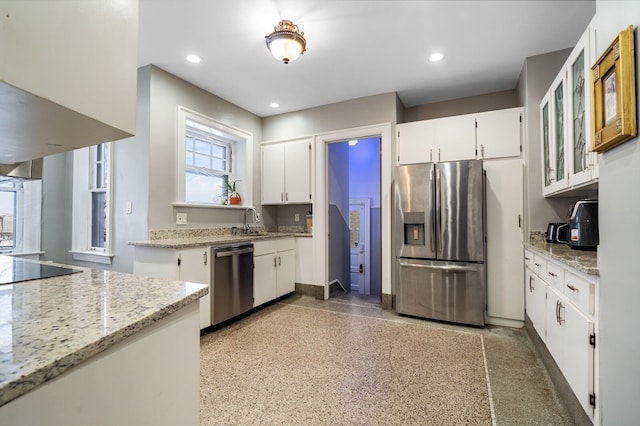 kitchen featuring white cabinets, light stone counters, sink, and appliances with stainless steel finishes