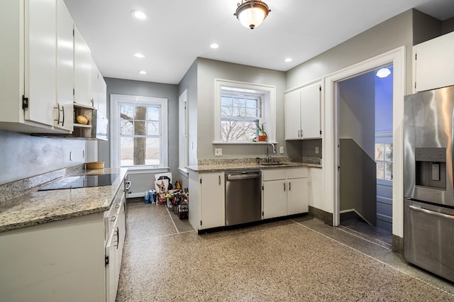 kitchen featuring light stone counters, sink, white cabinetry, and stainless steel appliances