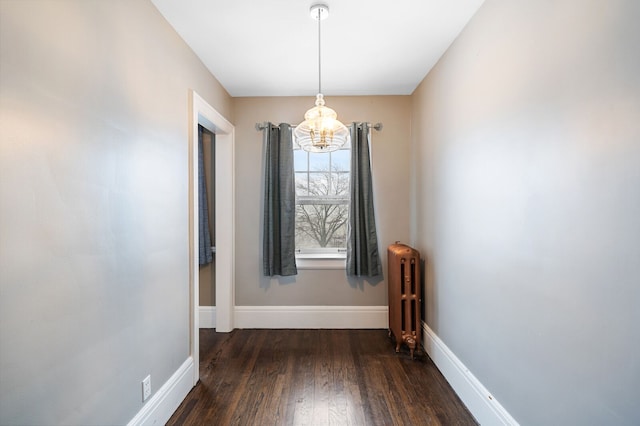 unfurnished dining area with dark hardwood / wood-style floors and radiator