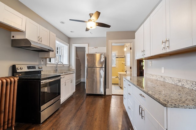 kitchen featuring light stone counters, stainless steel appliances, ceiling fan, dark wood-type flooring, and white cabinetry