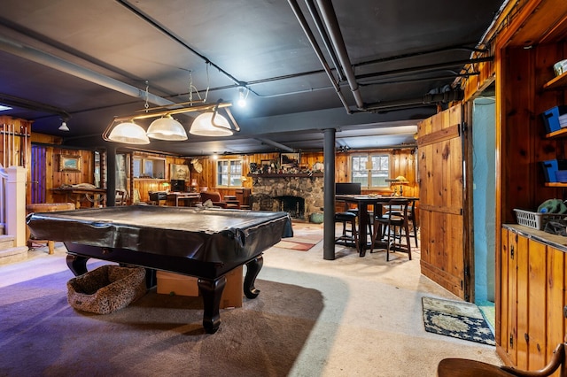 recreation room featuring wood walls, a stone fireplace, and billiards