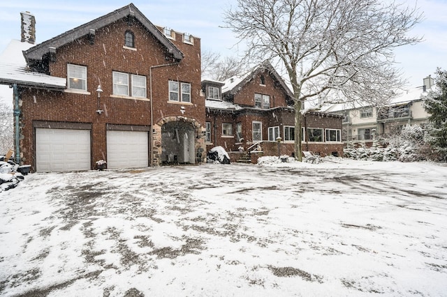 snow covered house with a garage