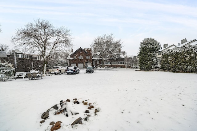 yard covered in snow featuring a garage