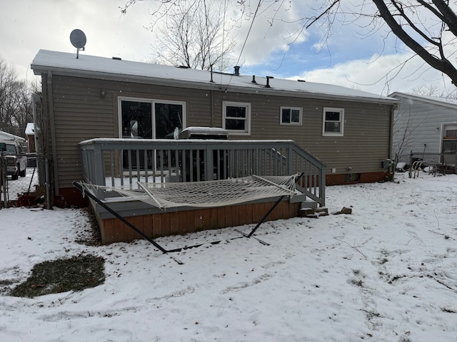 snow covered rear of property featuring a deck