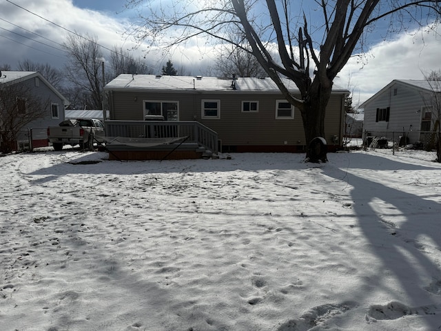 view of snow covered back of property