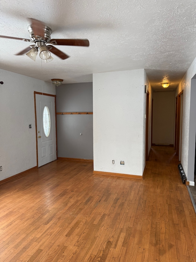 interior space featuring hardwood / wood-style floors, ceiling fan, and a textured ceiling