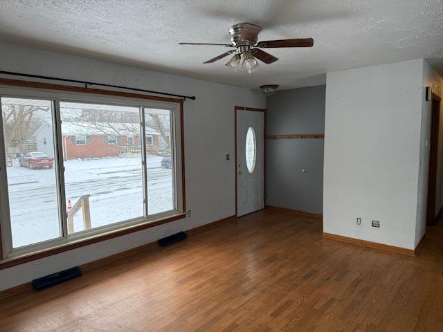 foyer with hardwood / wood-style flooring, ceiling fan, and a textured ceiling