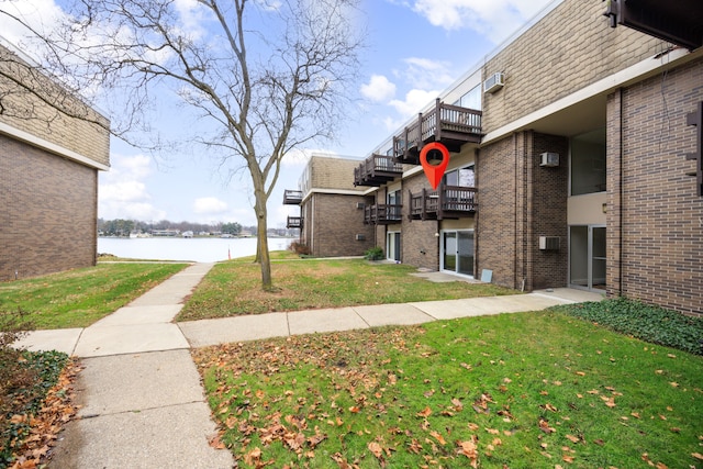 view of home's community with a lawn and a water view