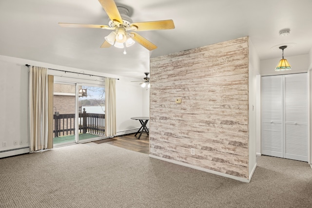 carpeted empty room featuring ceiling fan and wood walls