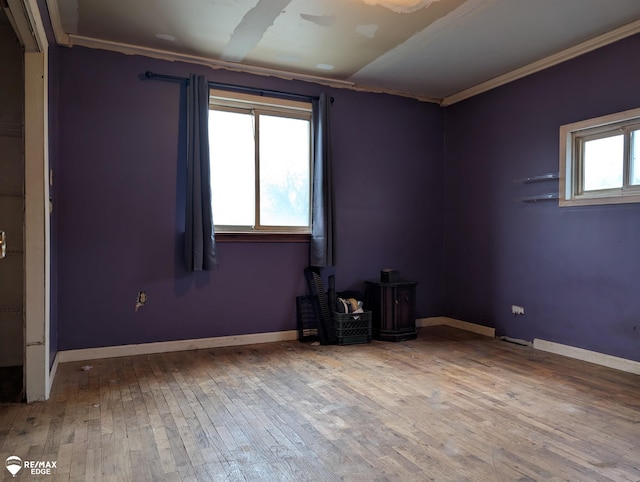 empty room with hardwood / wood-style floors and ornamental molding