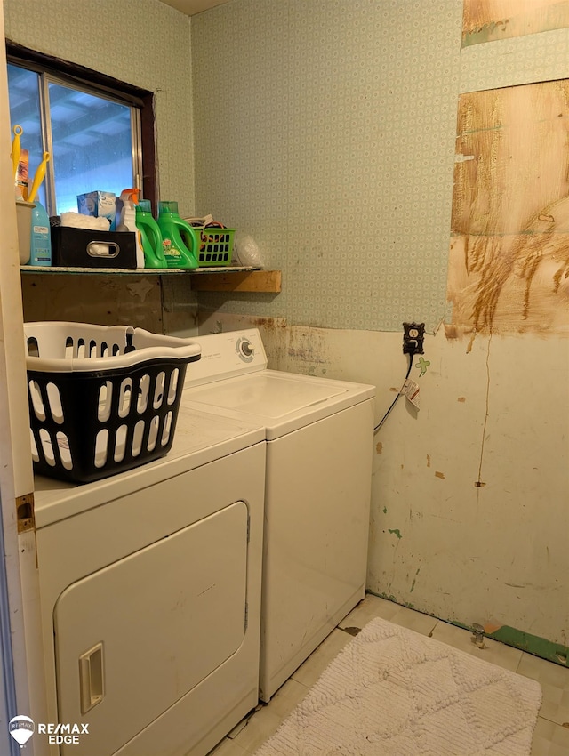 clothes washing area featuring washer and clothes dryer and light tile patterned floors