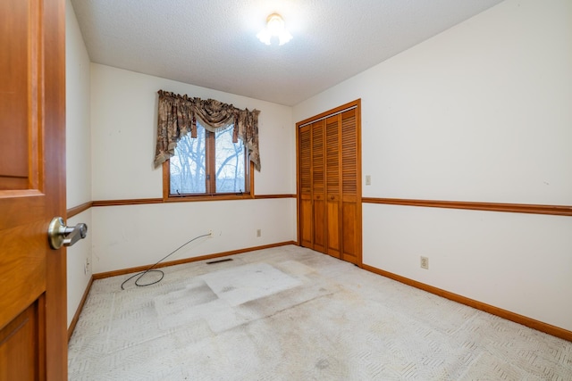 carpeted spare room featuring a textured ceiling