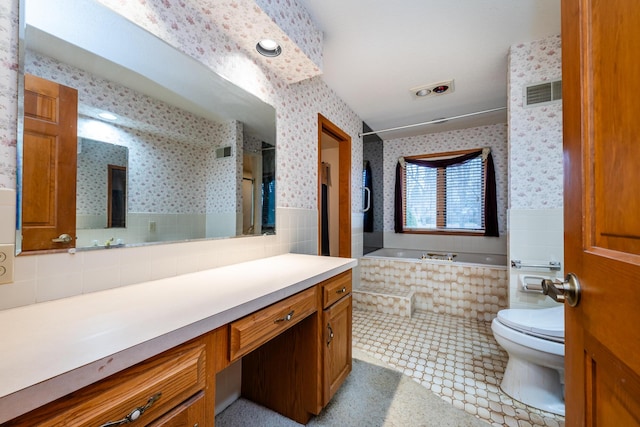 bathroom with tile patterned floors, tiled bath, vanity, and toilet