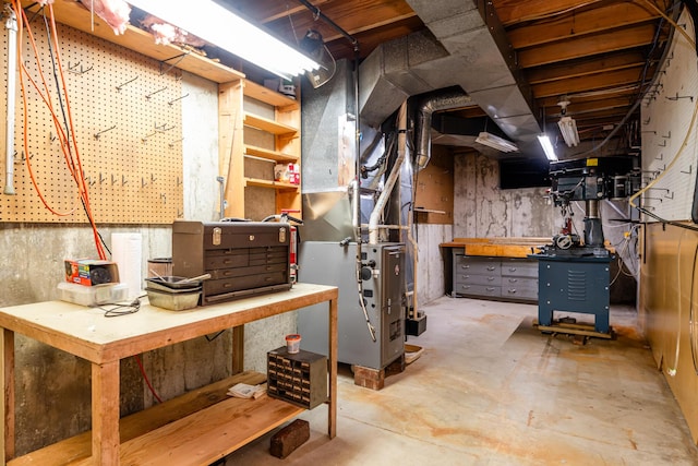 basement with a workshop area and heating unit