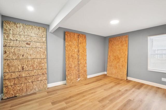 unfurnished room featuring beam ceiling and wood-type flooring