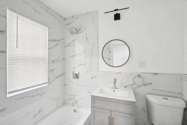 full bathroom featuring toilet, vanity, tiled shower / bath combo, and tile walls