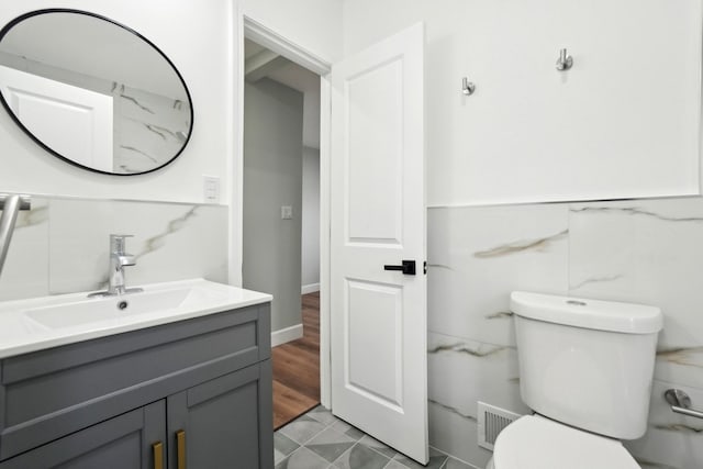 bathroom with tile patterned flooring, vanity, and toilet