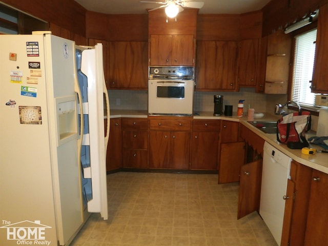 kitchen with ceiling fan, white appliances, sink, and tasteful backsplash