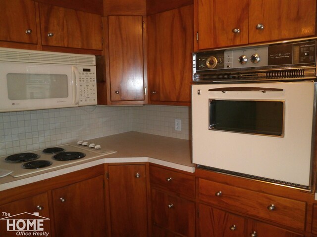 kitchen with backsplash and white appliances