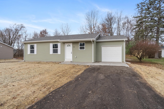 single story home featuring aphalt driveway, roof with shingles, and an attached garage