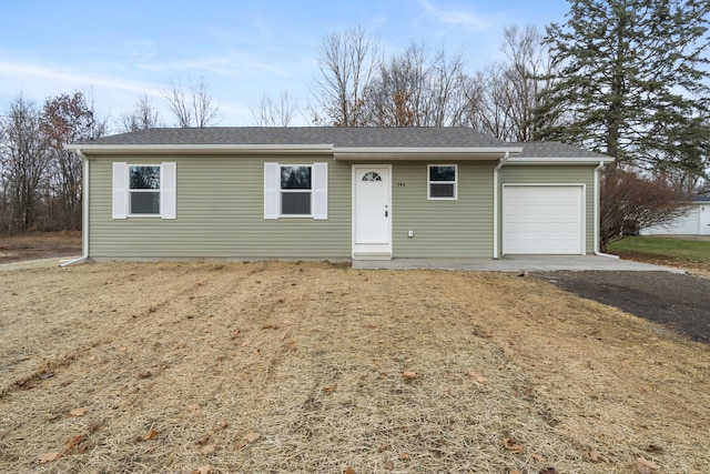 ranch-style house featuring driveway, a shingled roof, and an attached garage