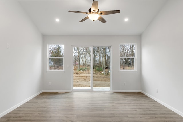 unfurnished room featuring recessed lighting, wood finished floors, and baseboards