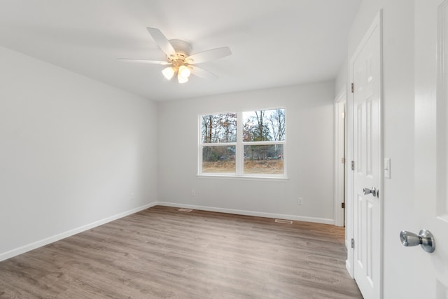 unfurnished bedroom with ceiling fan, light wood-style floors, and baseboards