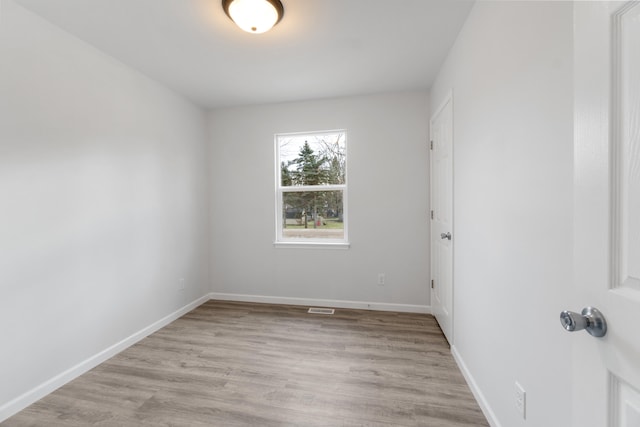 empty room featuring baseboards and light wood-style floors